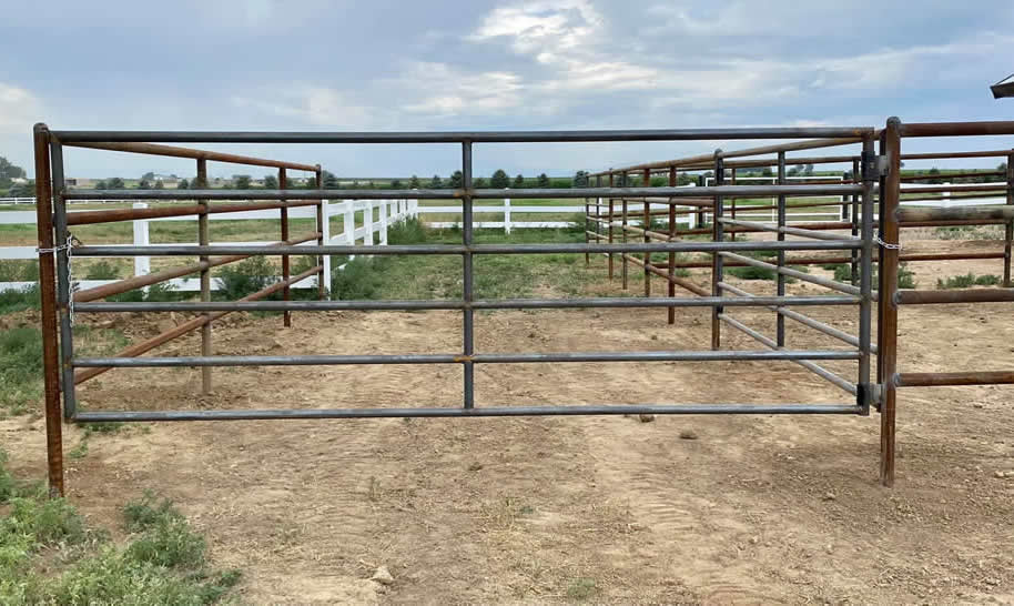 Pipe and Cable Fencing for a Riding Arena, complete with double gates and a custom flagpole. Construction by Integrity Welding Service LLC, servicing the Front Range of Colorado.